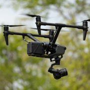 A black drone in the air.