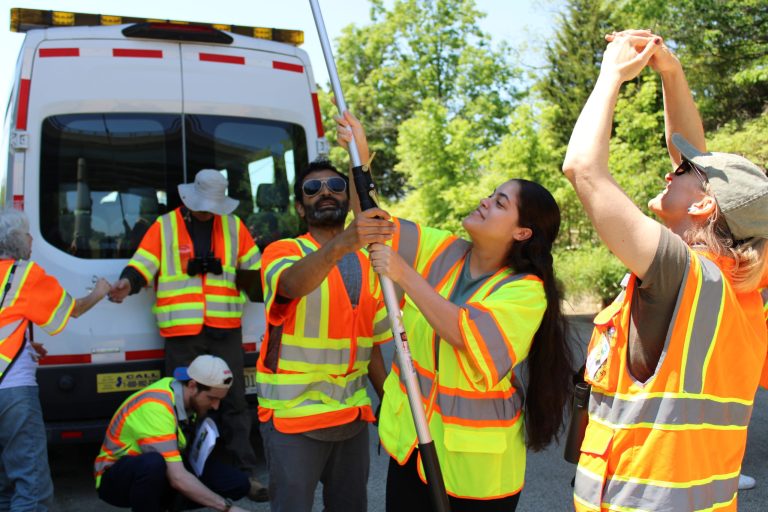 People in safety vests performing work