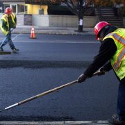 two road construction workers working on road asphalt