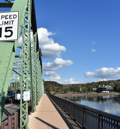 bridge beside a speed limit sign and river.