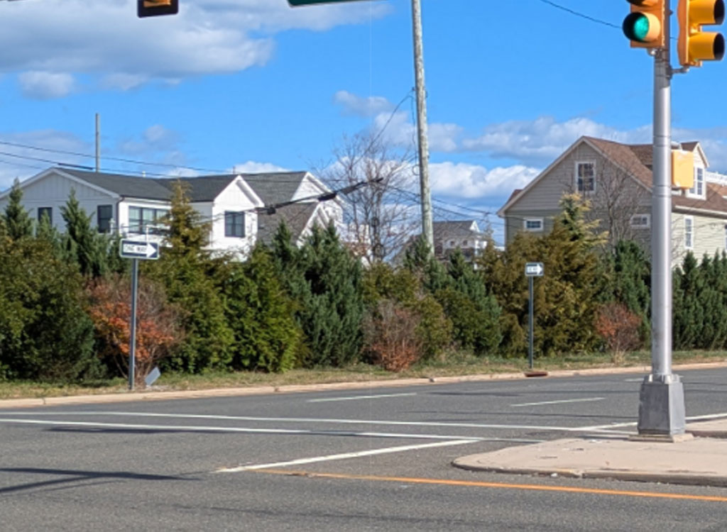 Street-level view of a Route 35 intersection with traffic signals and residential homes in the background.