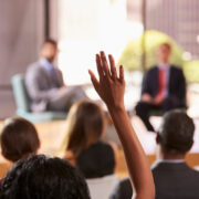 A hand raised during a workshop panel.