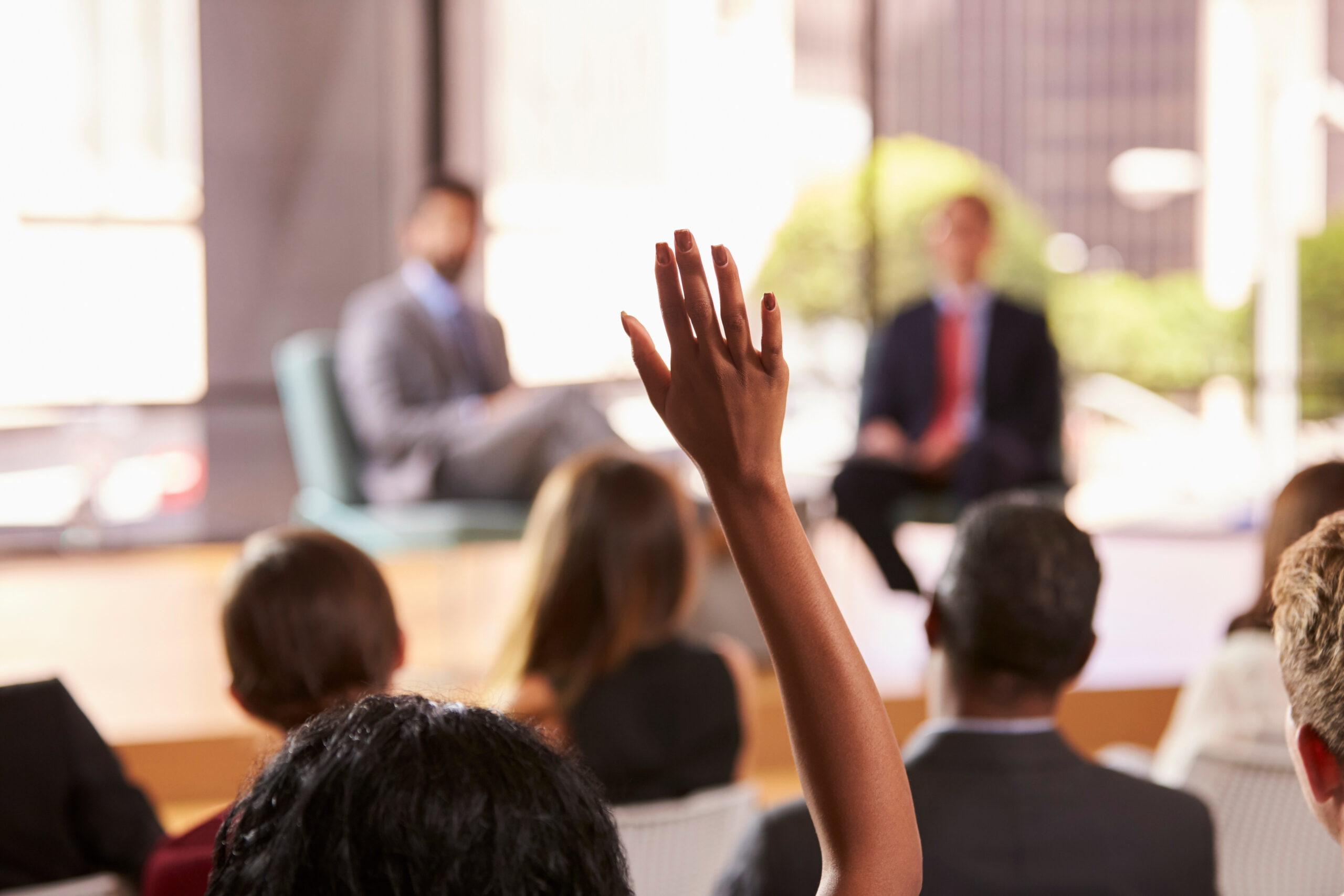 A hand raised during a workshop panel.