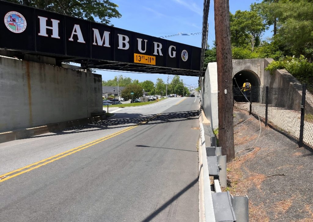 A railroad overpass marked 'Hamburg' with a 13-foot 11-inch clearance sign spans Route 23 in Hamburg, New Jersey.
